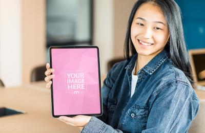 Smiling Woman Holding iPad Mockup in an Office
